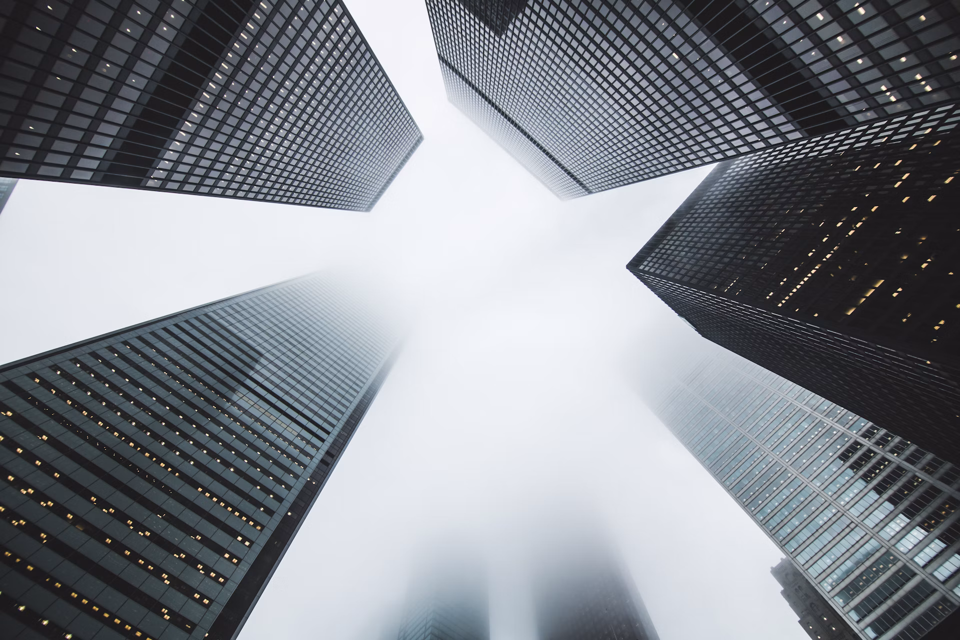 Looking up at modern office towers against a bright sky